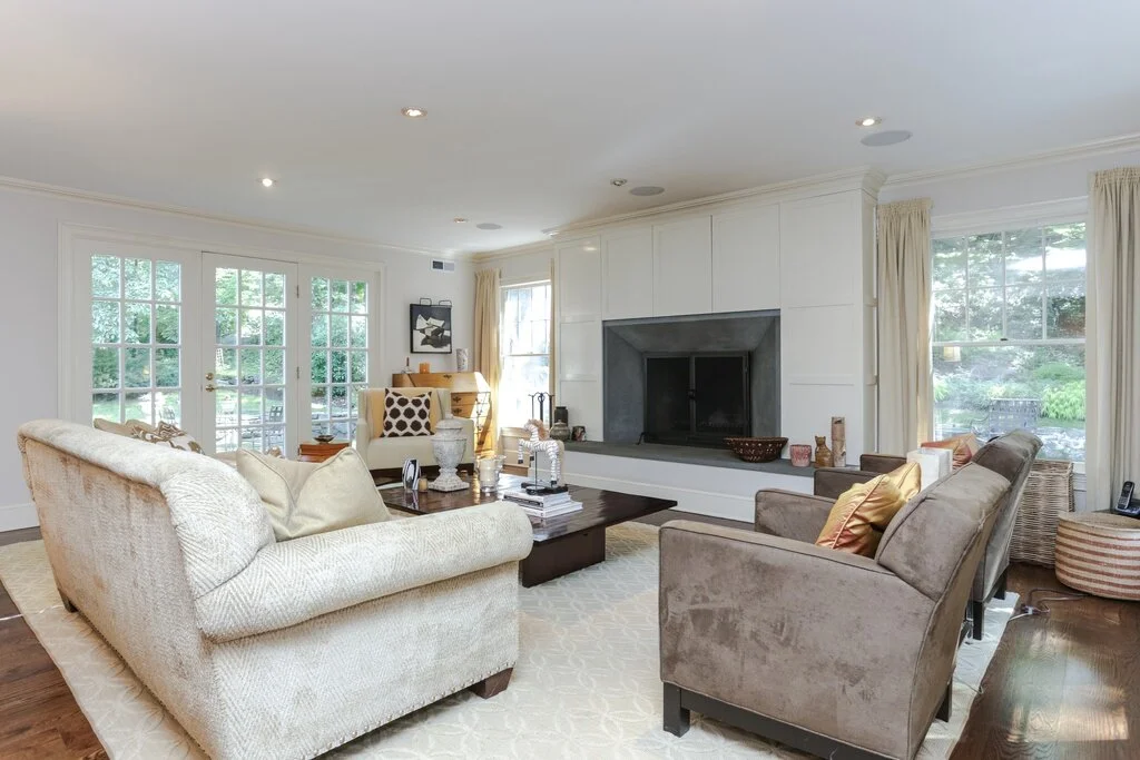Living room with beige sofa, brown armchairs and fireplace